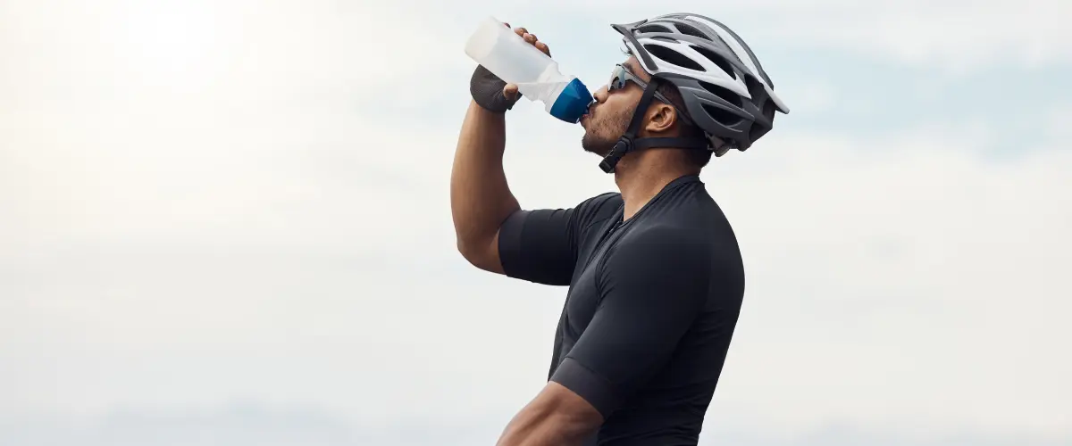Ciclista bebiendo agua de una botella de plástico